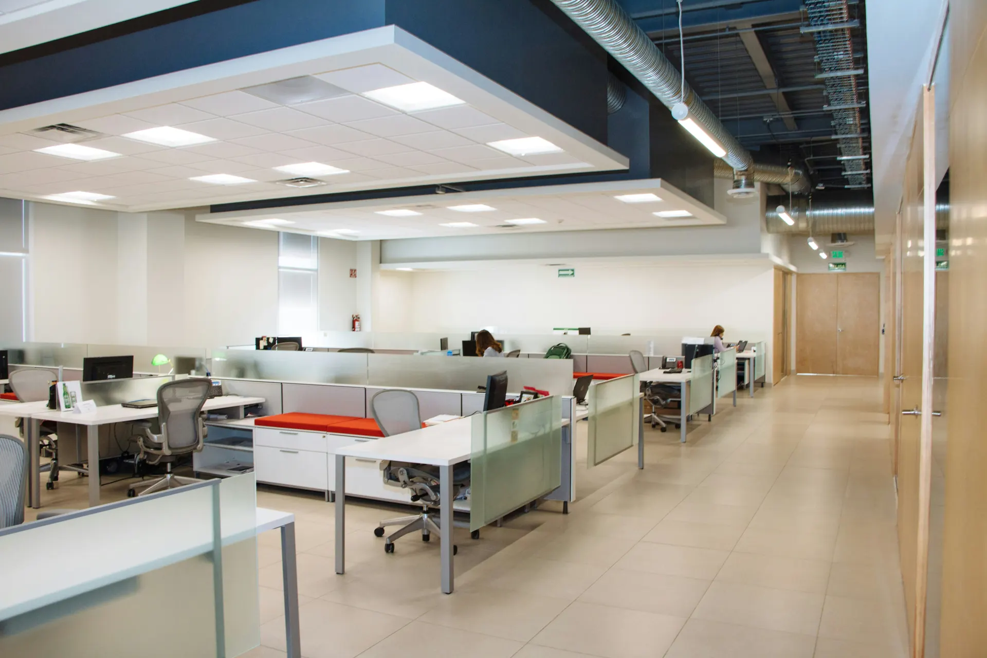 Open-plan office with workstations under an exposed-duct ceiling